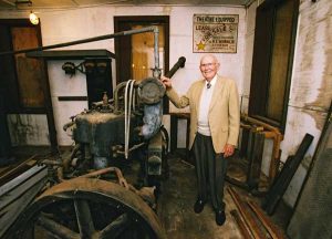 Capt. Richard Norman, III, son of silent filmmaker Richard Norman, standing with one of his father's generators used to power filmmaking equipment.